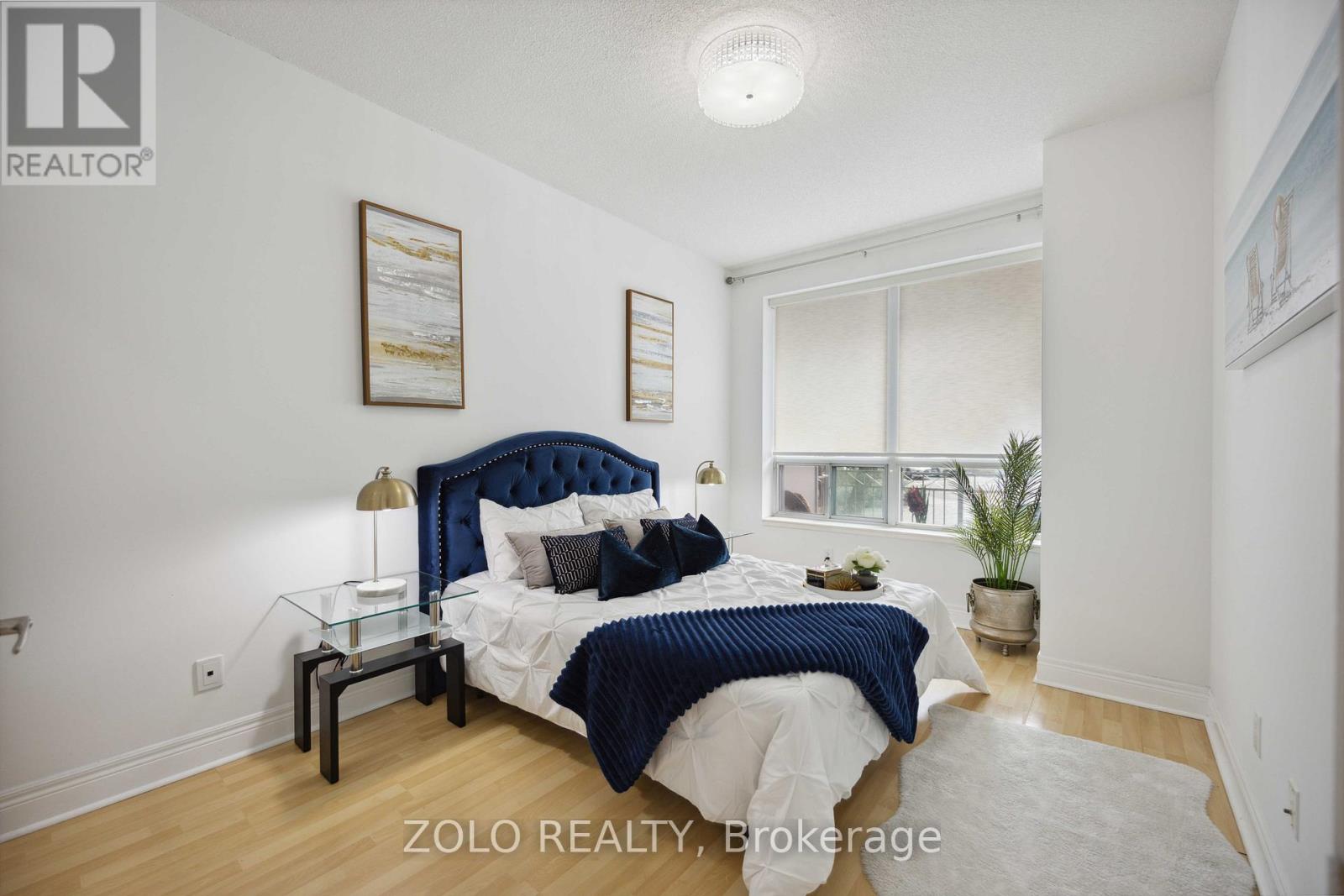 A bedroom with a bed, nightstands, and a window.