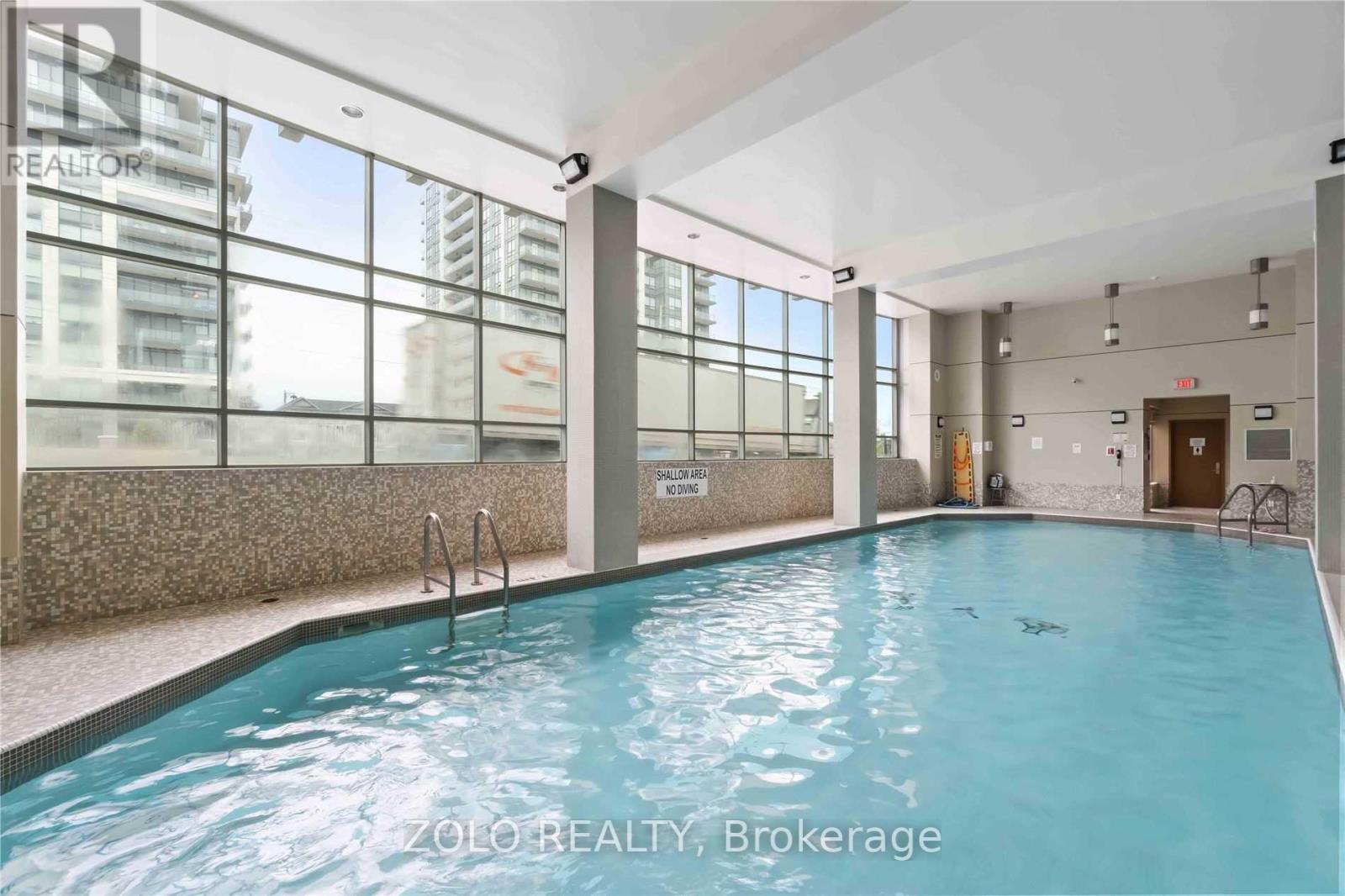 A pool inside a building with a sign that says "ZOLO REALTY Brokerage".