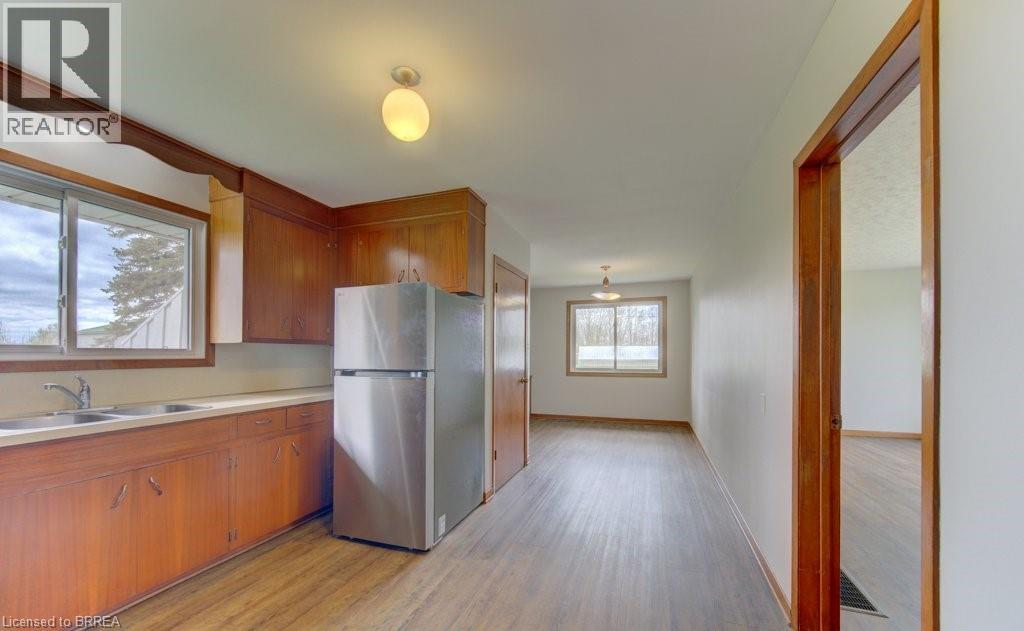 A kitchen with wooden cabinets and a refrigerator.