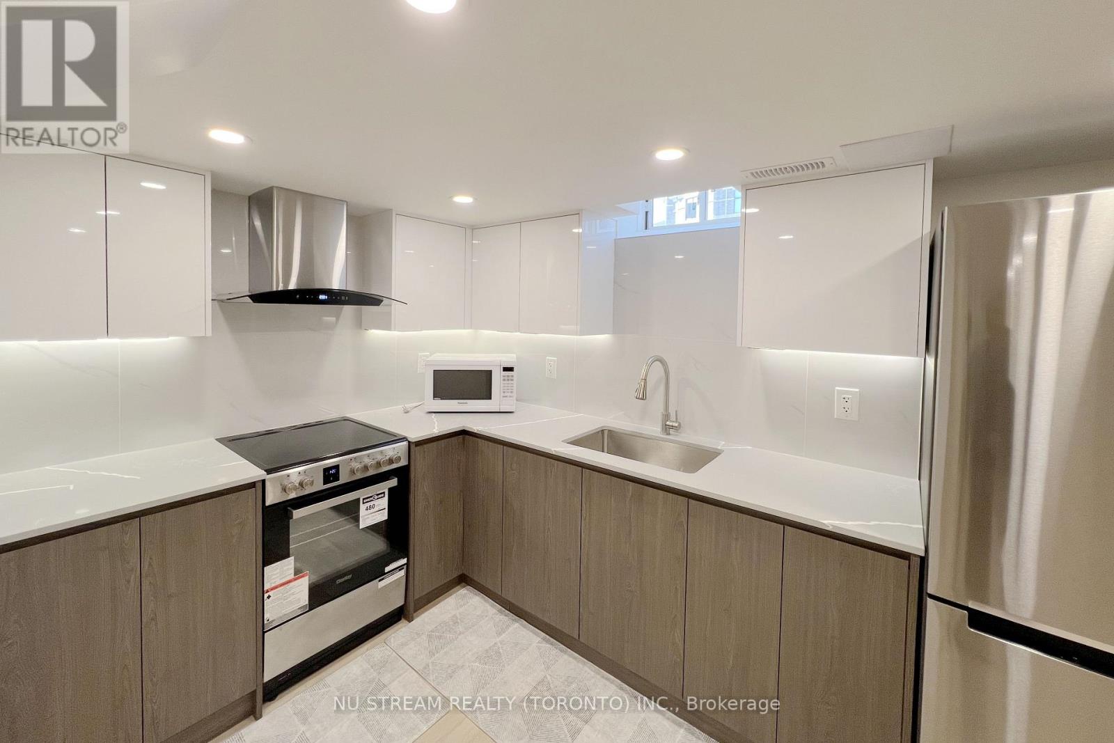 A modern kitchen with a stove top oven and a microwave.