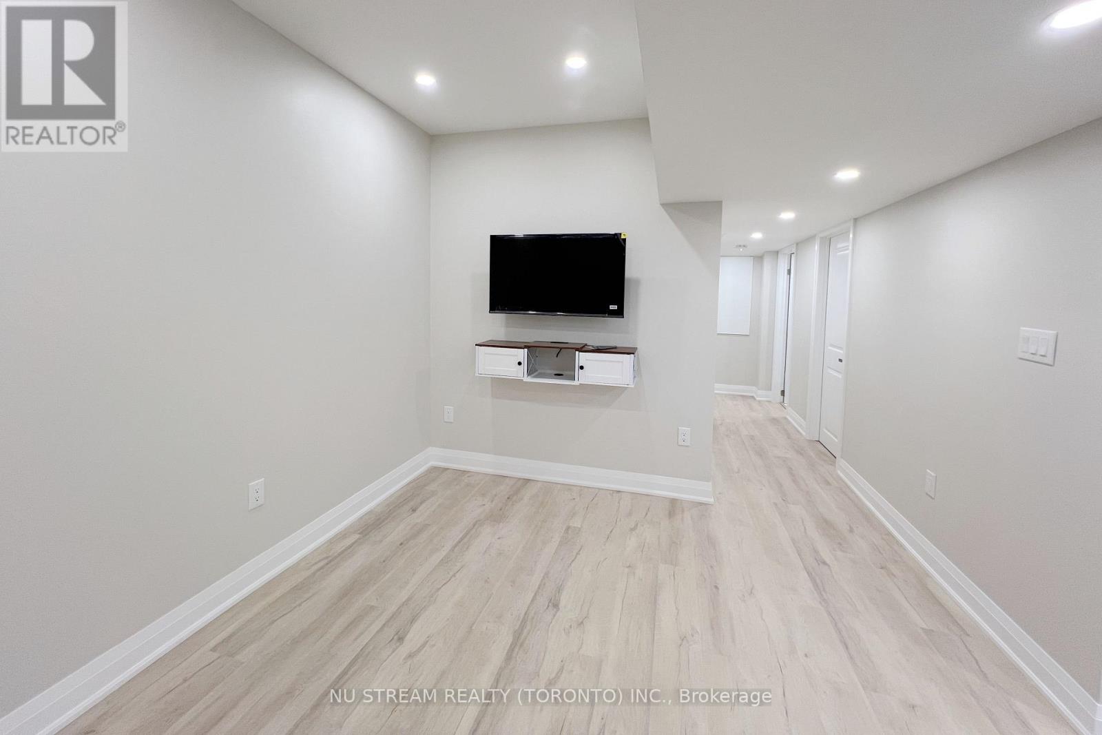 A spacious room with a flat screen TV mounted on the wall.