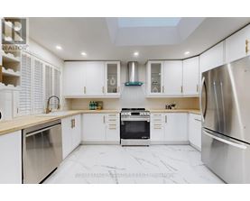 A modern kitchen with white cabinets and stainless steel appliances.