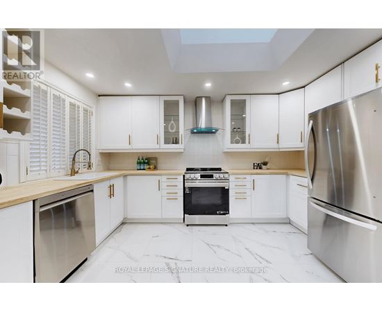 A modern kitchen with white cabinets and stainless steel appliances.