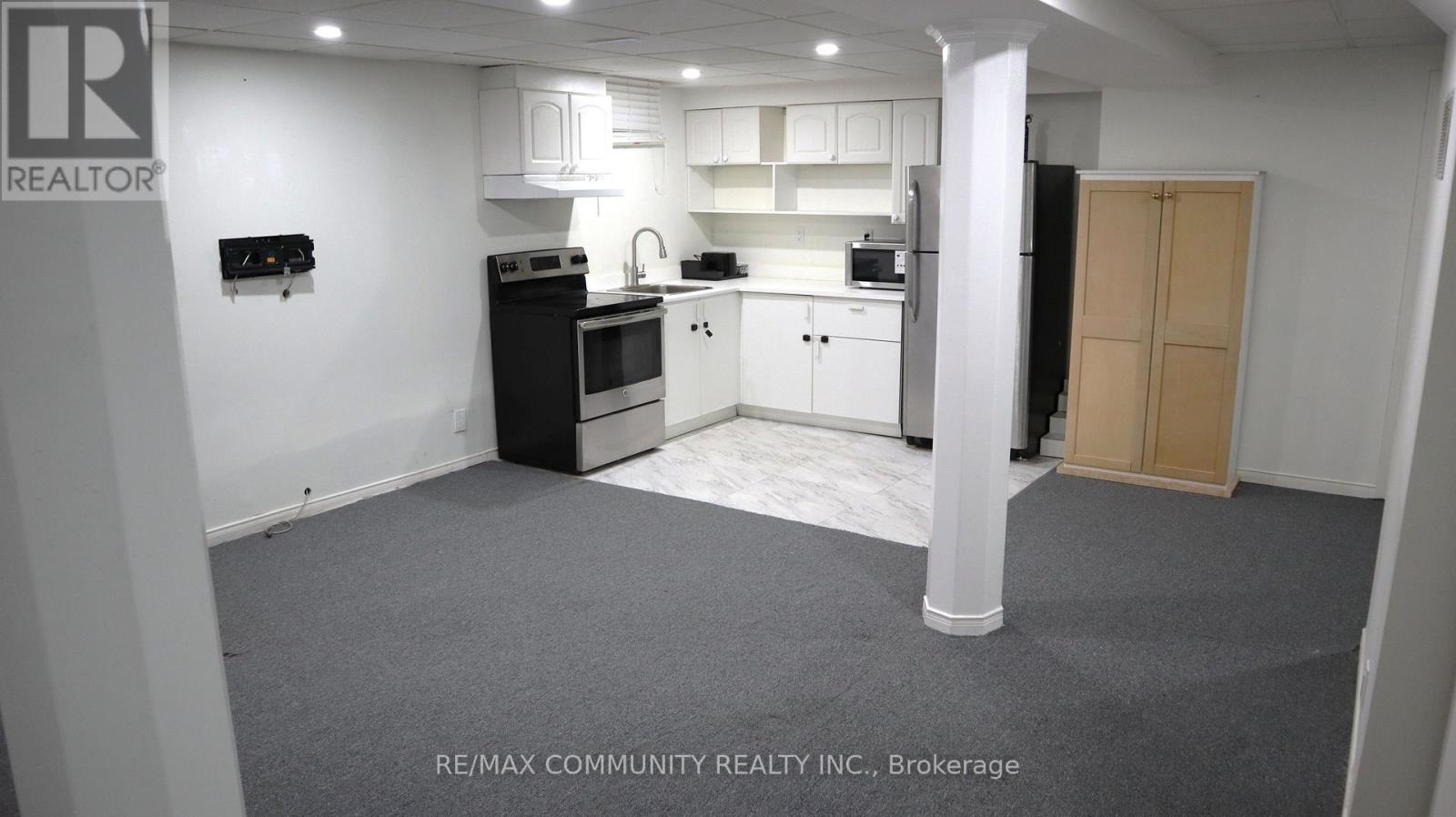 A kitchen area with white cabinets and appliances.