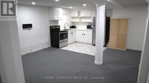 A kitchen area with white cabinets and appliances.