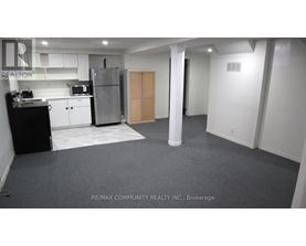 A kitchen area with a refrigerator, toaster, and cabinets.