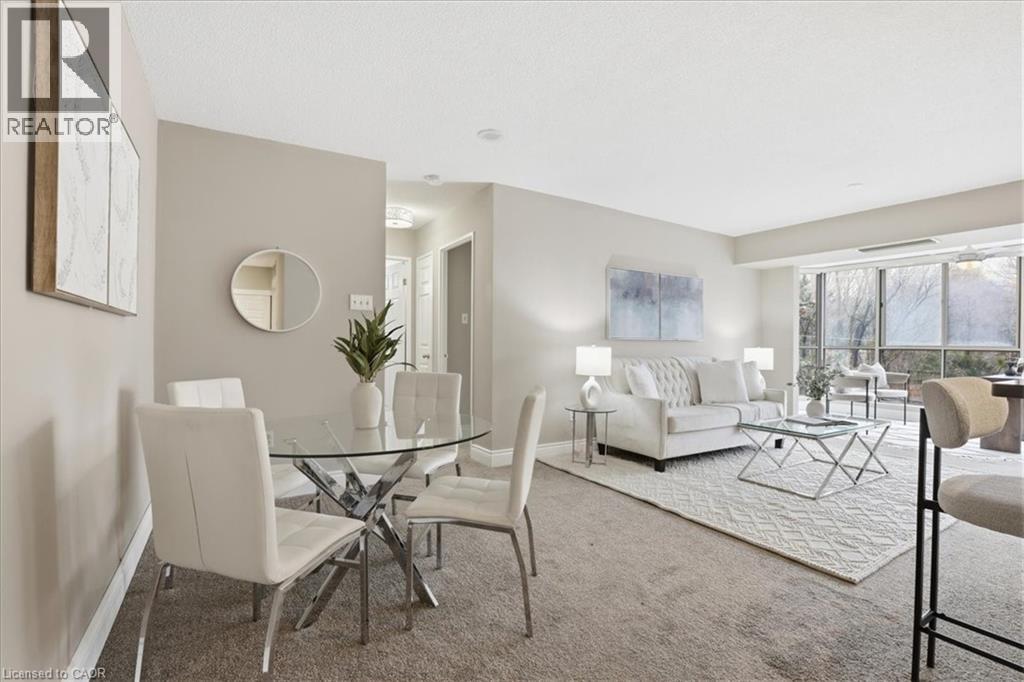 A well-lit living room with a glass table and white chairs.