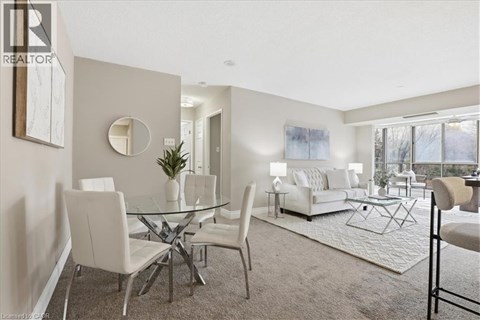 A well-lit living room with a glass table and white chairs.