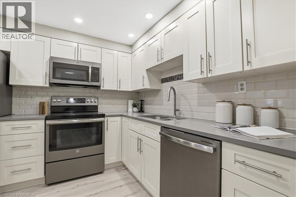A modern kitchen with white cabinets and stainless steel appliances.