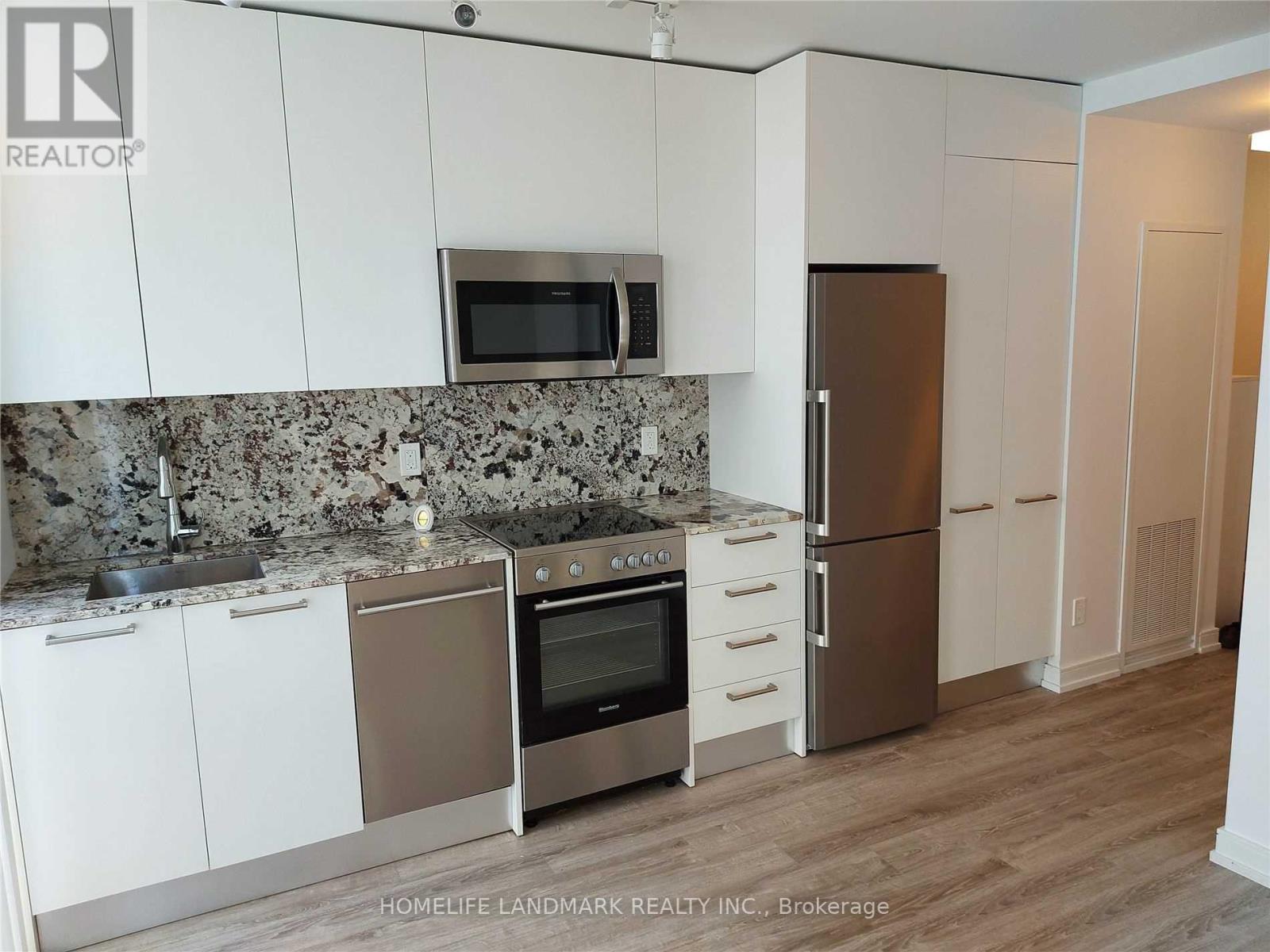A kitchen with white cabinets and a granite countertop.