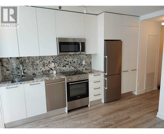 A kitchen with white cabinets and a granite countertop.