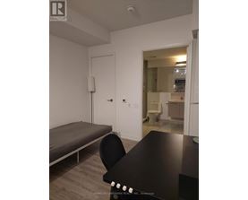 A black table with a chair in front of a white wall.