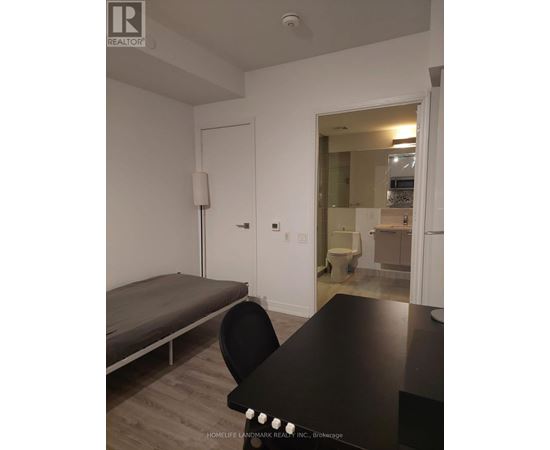 A black table with a chair in front of a white wall.