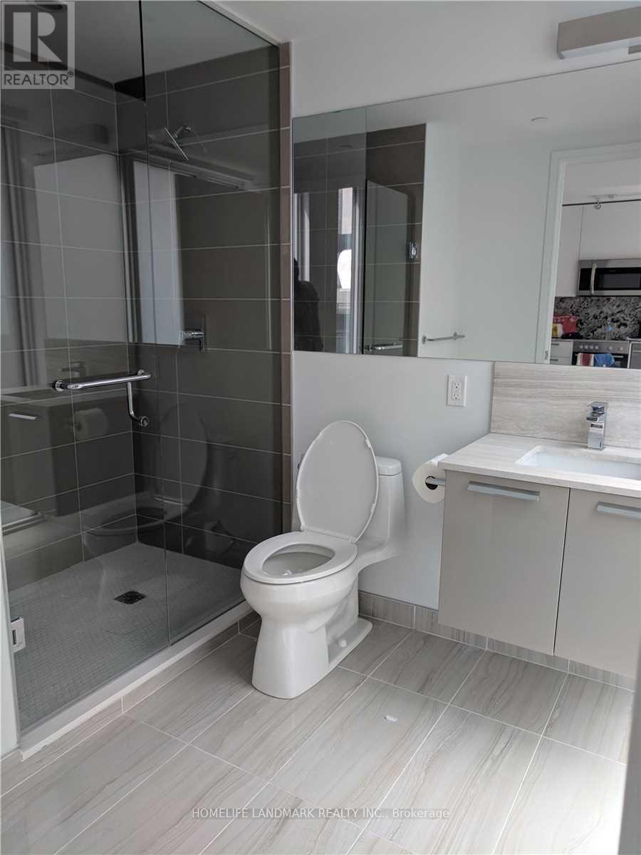 A white toilet in a bathroom with a glass shower door.
