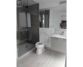 A white toilet in a bathroom with a glass shower door.