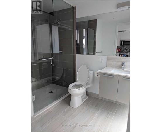 A white toilet in a bathroom with a glass shower door.