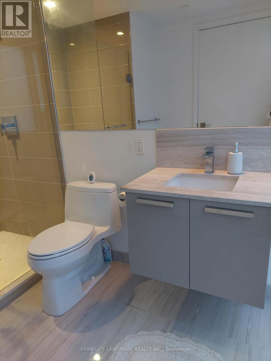 A white toilet sits in a bathroom with a wooden floor.