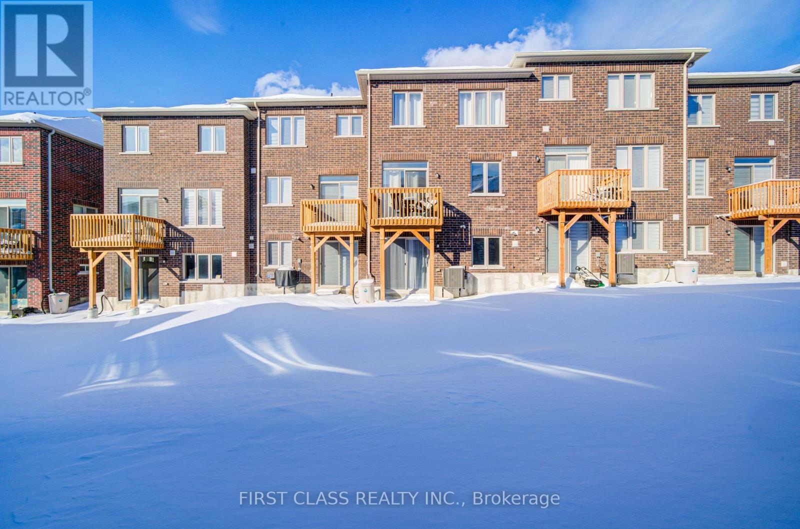 A building with a balcony and a snowy ground in front of it.