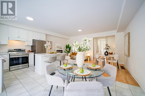 A modern kitchen with a glass dining table set for two.