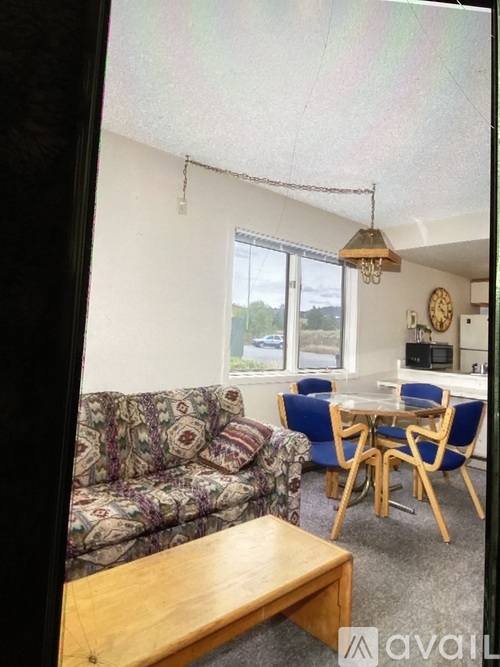 A living room with a couch, chairs, and a table.