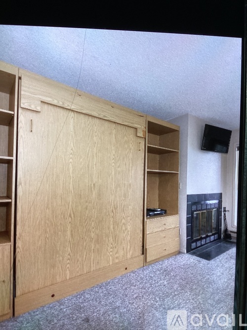 A room with a fireplace and built-in shelves.