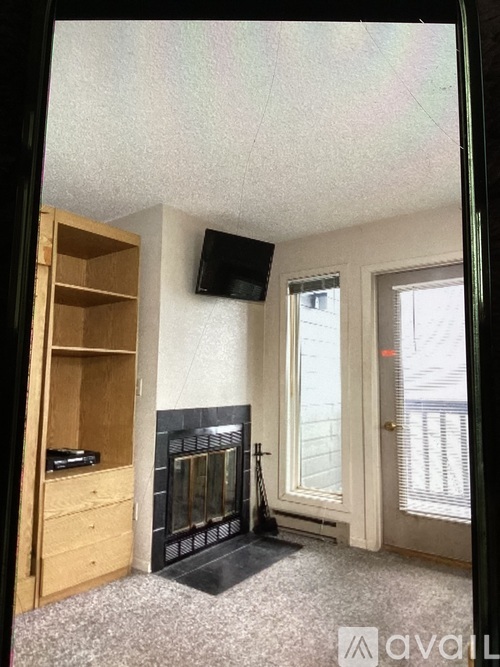 A room with a fireplace and a TV mounted on the wall.