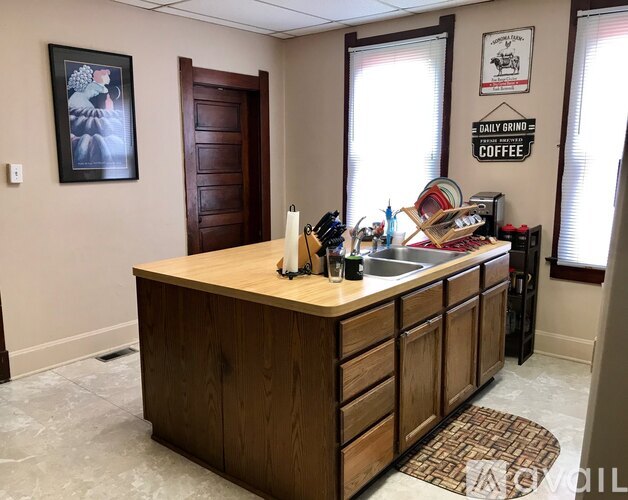 A kitchen with a wooden island and a framed picture on the wall.