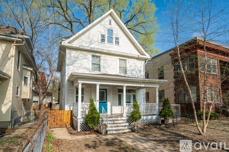 A house with a blue door and a white porch is for sale.