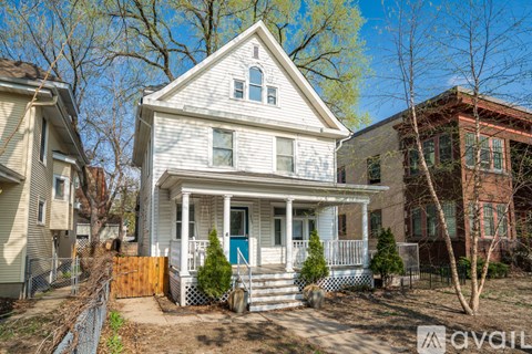 A house with a blue door and a white porch is for sale.