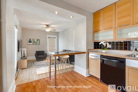 A kitchen with wooden cabinets and a black dishwasher.
