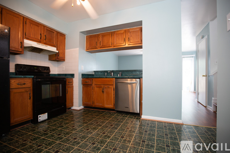 A kitchen with wooden cabinets and a black oven.