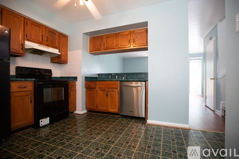 A kitchen with wooden cabinets and a black oven.