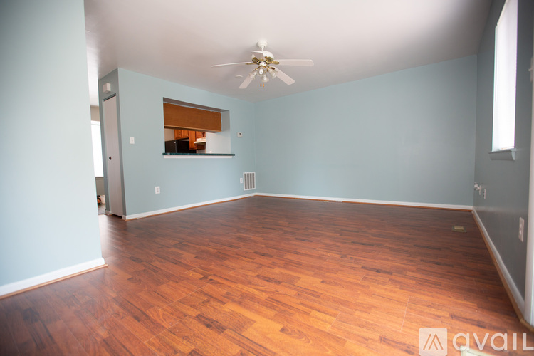 A room with wooden flooring and a ceiling fan.