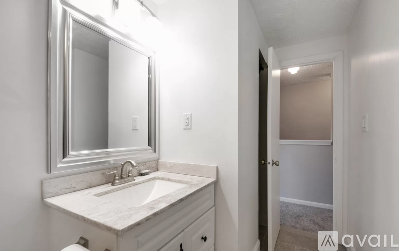 A bathroom with a sink, mirror, and toilet.
