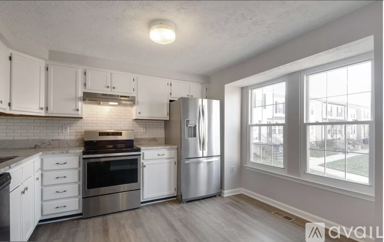 A kitchen with white cabinets and stainless steel appliances.
