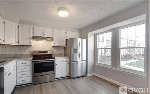 A kitchen with white cabinets and stainless steel appliances.