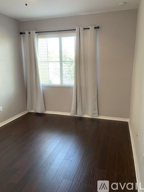 A room with a window and curtains.