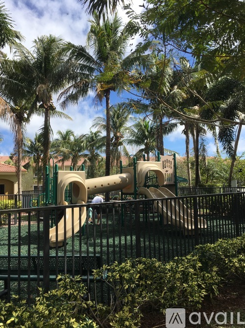 A playground with a slide and a person standing by it.