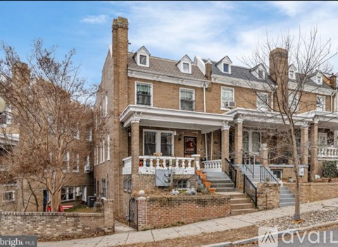 A large, two-story house with a brick facade and a front porch.