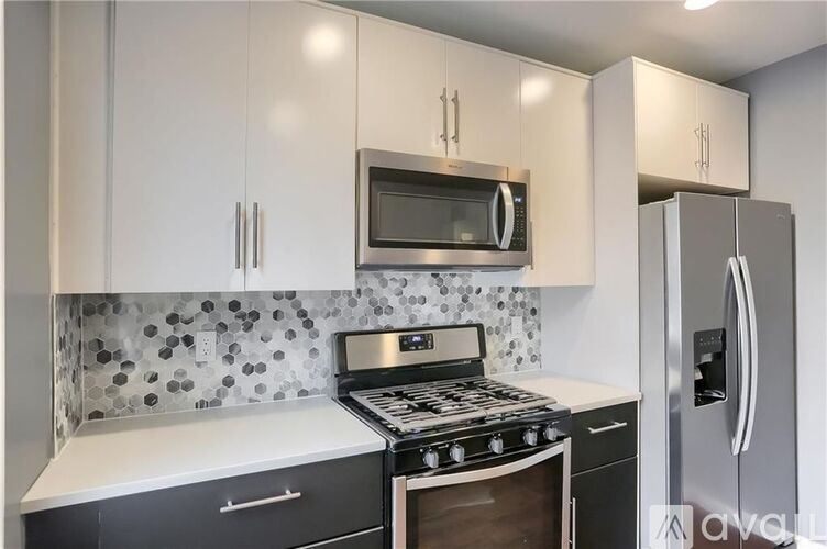 A kitchen with a stove, microwave, and refrigerator.