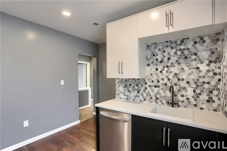 A kitchen with a sink and a trash can.