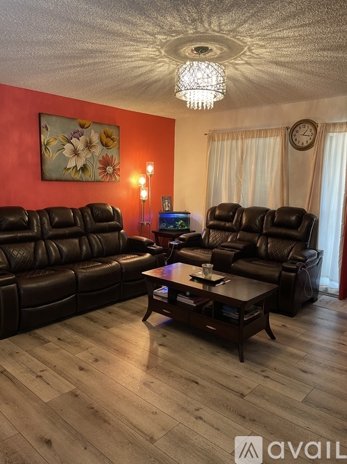 A living room with black leather sofas and a wooden coffee table.