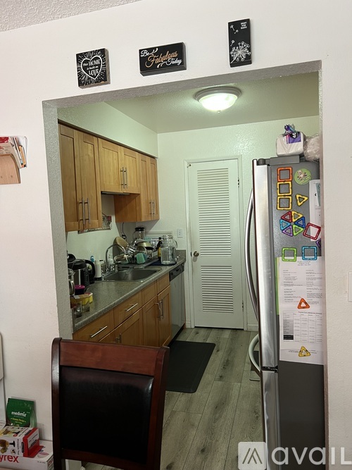 A kitchen with a fridge covered in magnets and stickers.