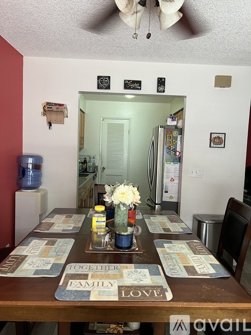 A dining room with a table set for a meal.