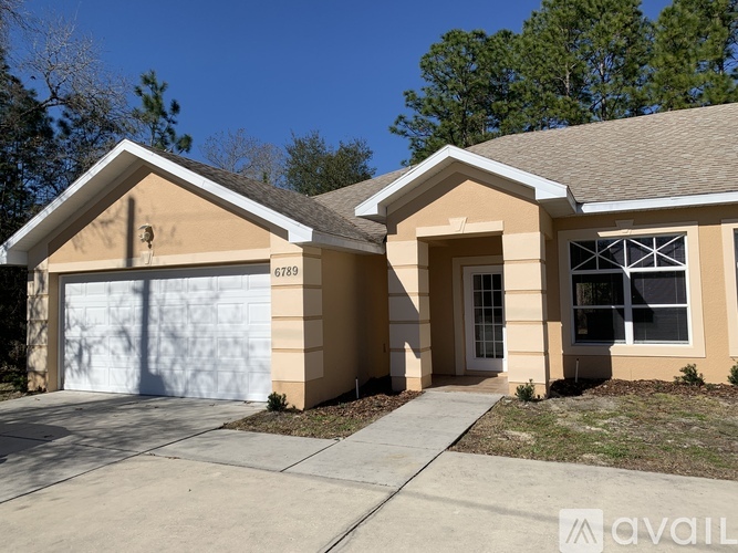 A two-story house with a garage is available for sale.