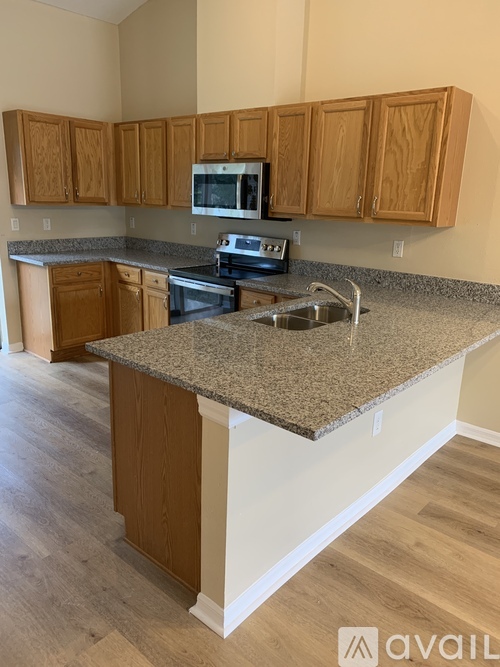A kitchen with wooden cabinets and a granite countertop.