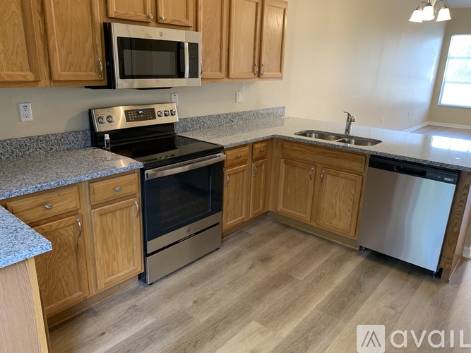 A kitchen with wooden cabinets and a granite countertop.