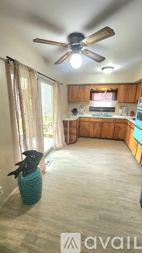 A kitchen with wooden cabinets and a ceiling fan.