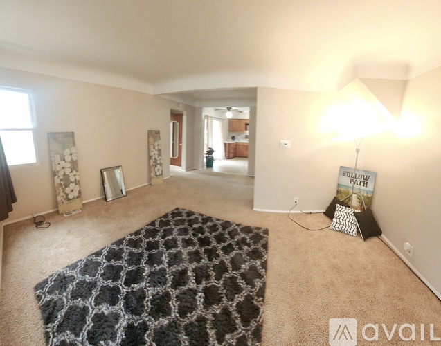 A spacious living room with a large rug and a sign that says "Follow Path".