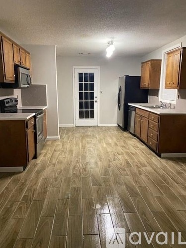A kitchen with wooden floors and cabinets.